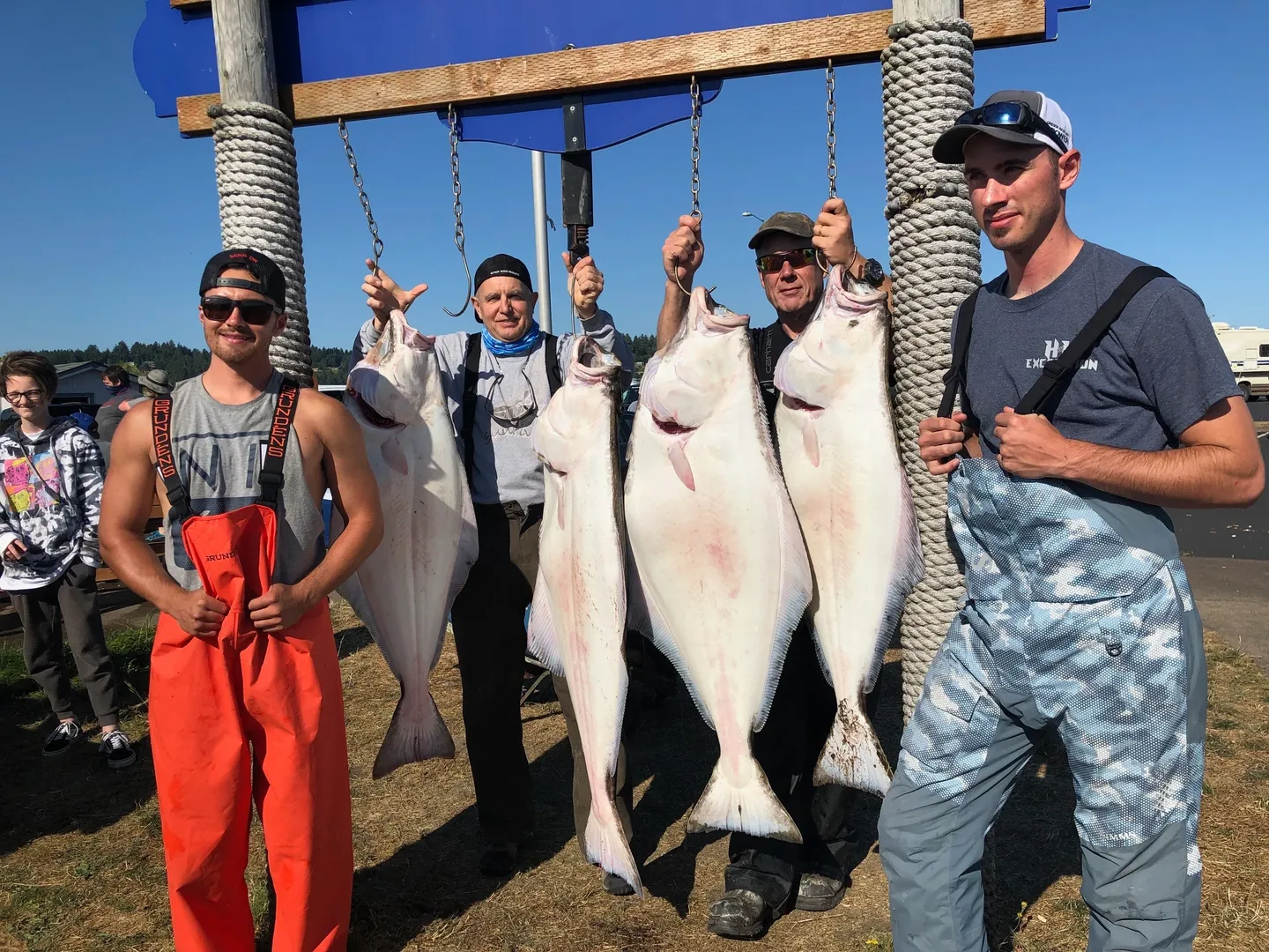 A group of people holding fish on a pole.