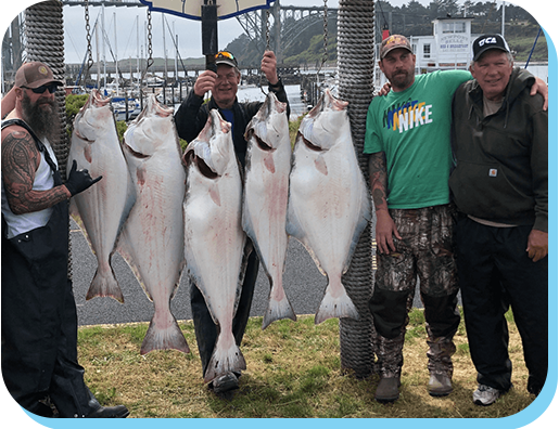 A group of men holding up fish on top of a dock.