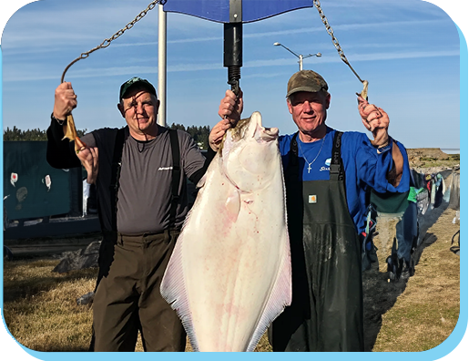 Two men holding a large fish under an umbrella.