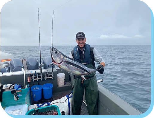 A man holding a fish on top of a boat.