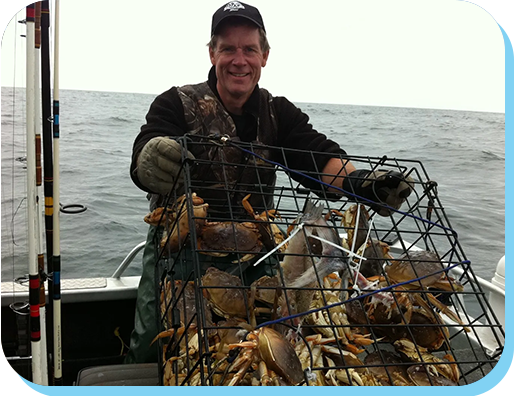 A man in a boat with a cage full of fish.