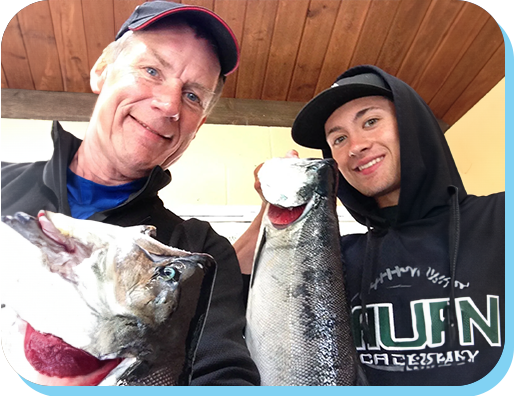 Two men holding fish in their hands.