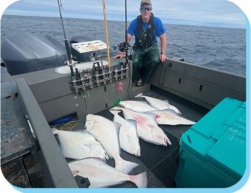 A man standing on the back of a boat with fish.