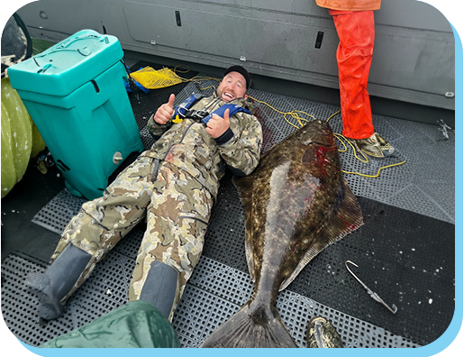 A man laying on the ground next to an animal.