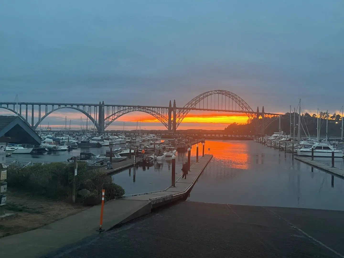 A sunset over the water with boats in it.